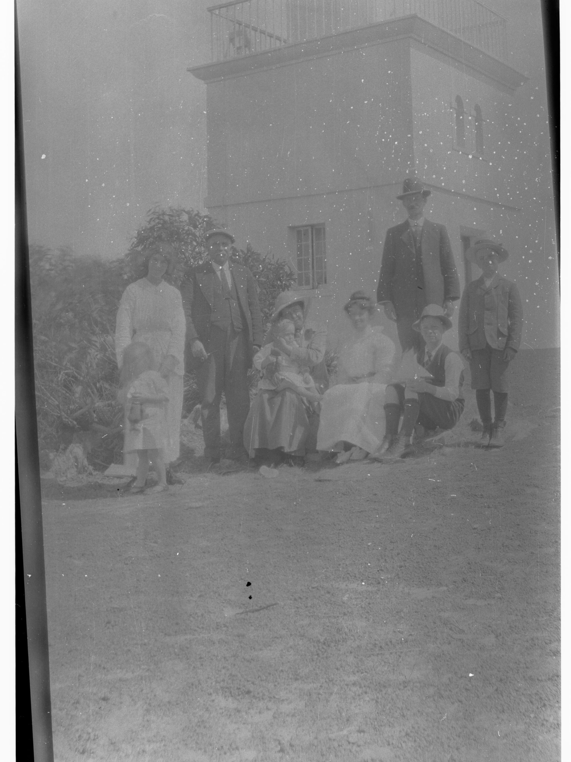 Family group sitting in front of a lighthouse