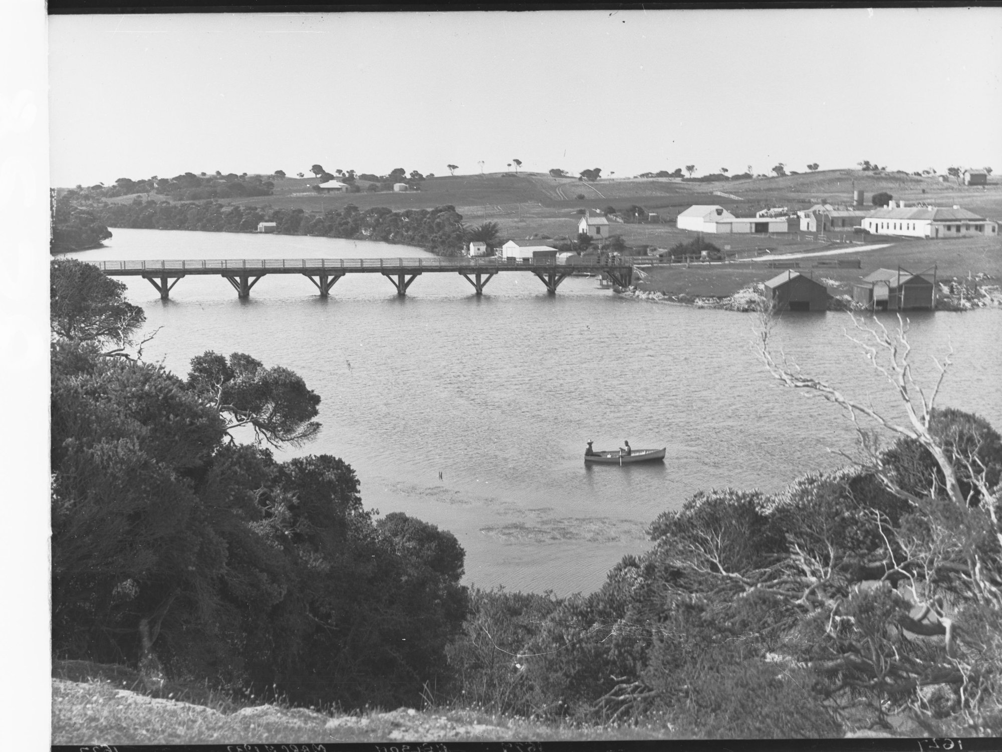 Two Men in Rowboat on Glenelg River with Housing in Background