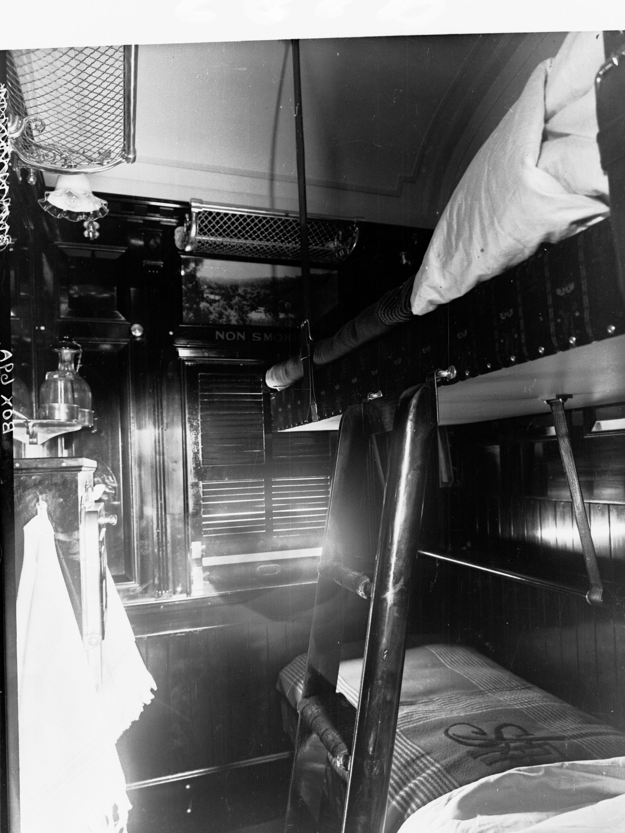 Sleeping compartment in a railway carriage showing bunk beds; and cupboard.