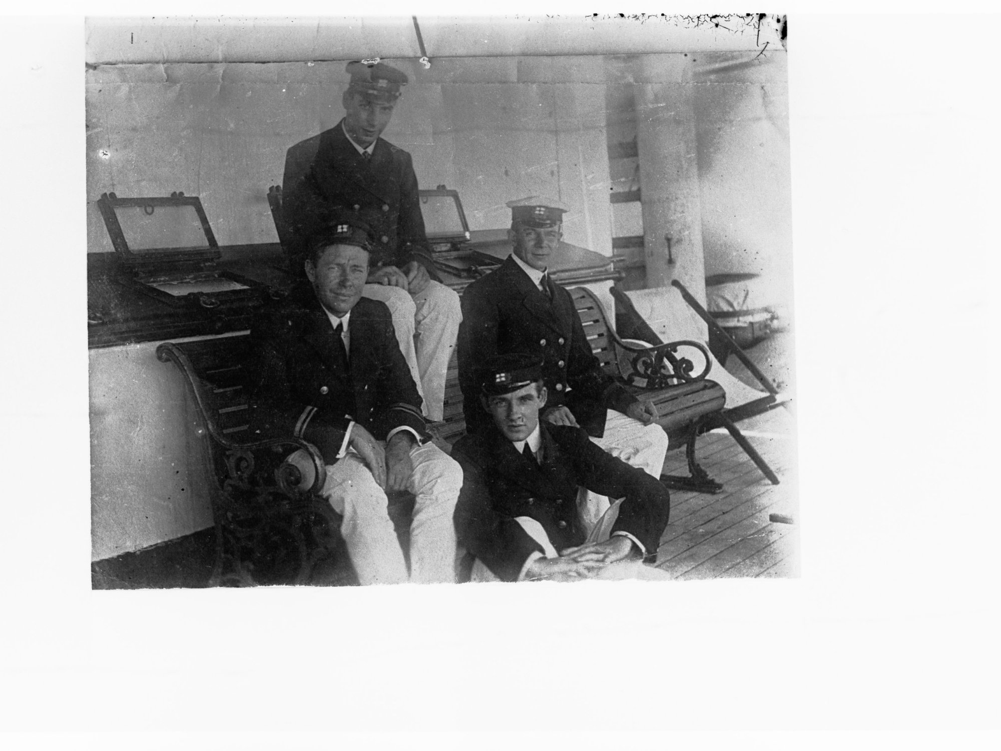 Four Navy men sitting on a bench