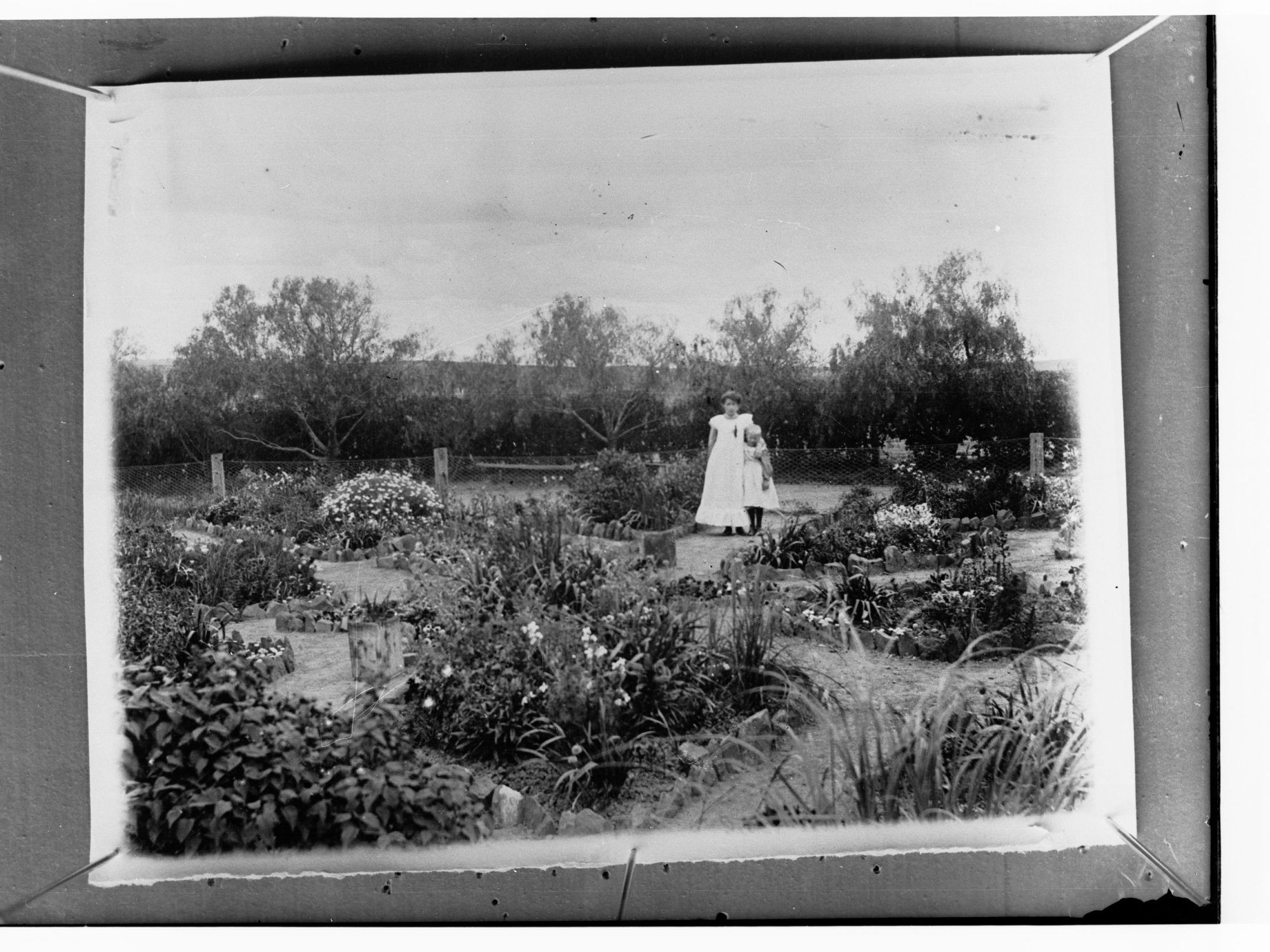 Mother and child standing near fence in garden