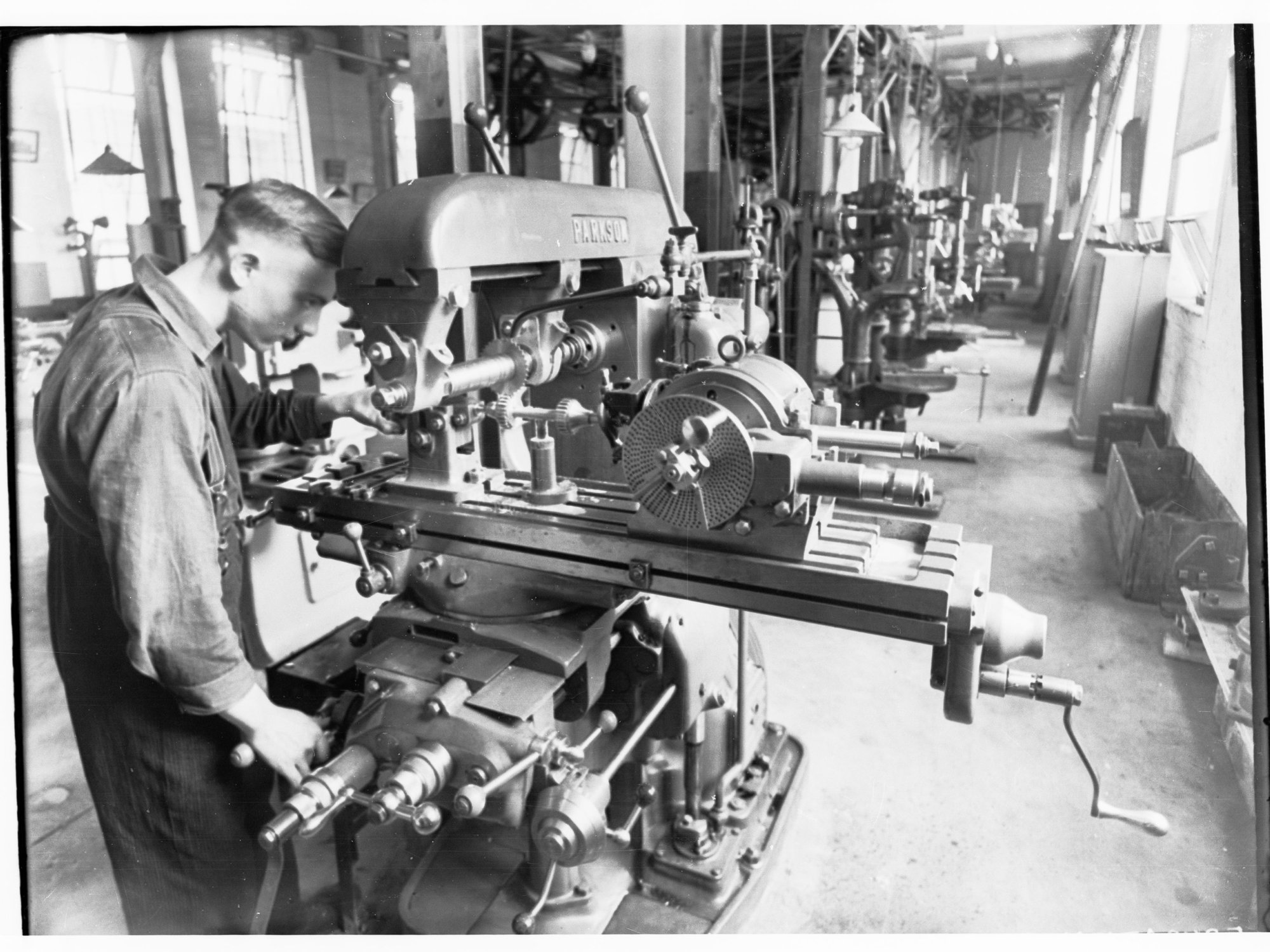 Student standing by a machine at Trades School