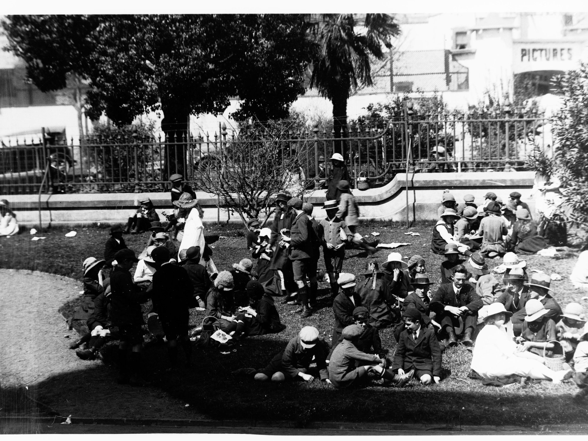 Children sitting on the grass at the Royal Adelaide Show Exhibition Building, North Terrace