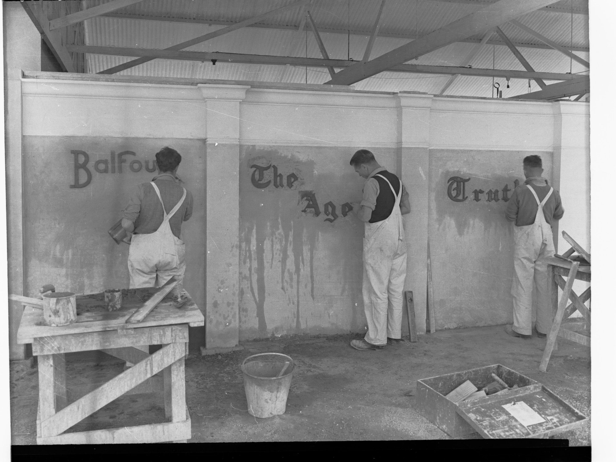 Sign writers showing three men doing different signs - BALFOURS, THE AGE, TRUTH signs