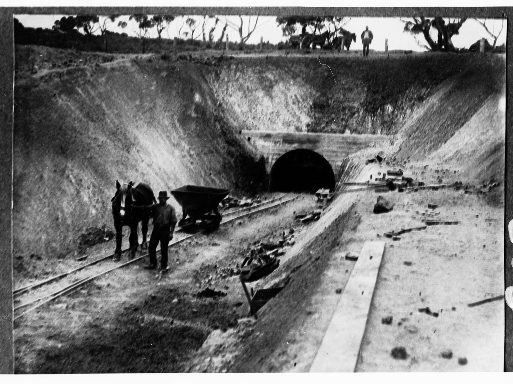 Construction of water culvert through hills - man and horse in foreground