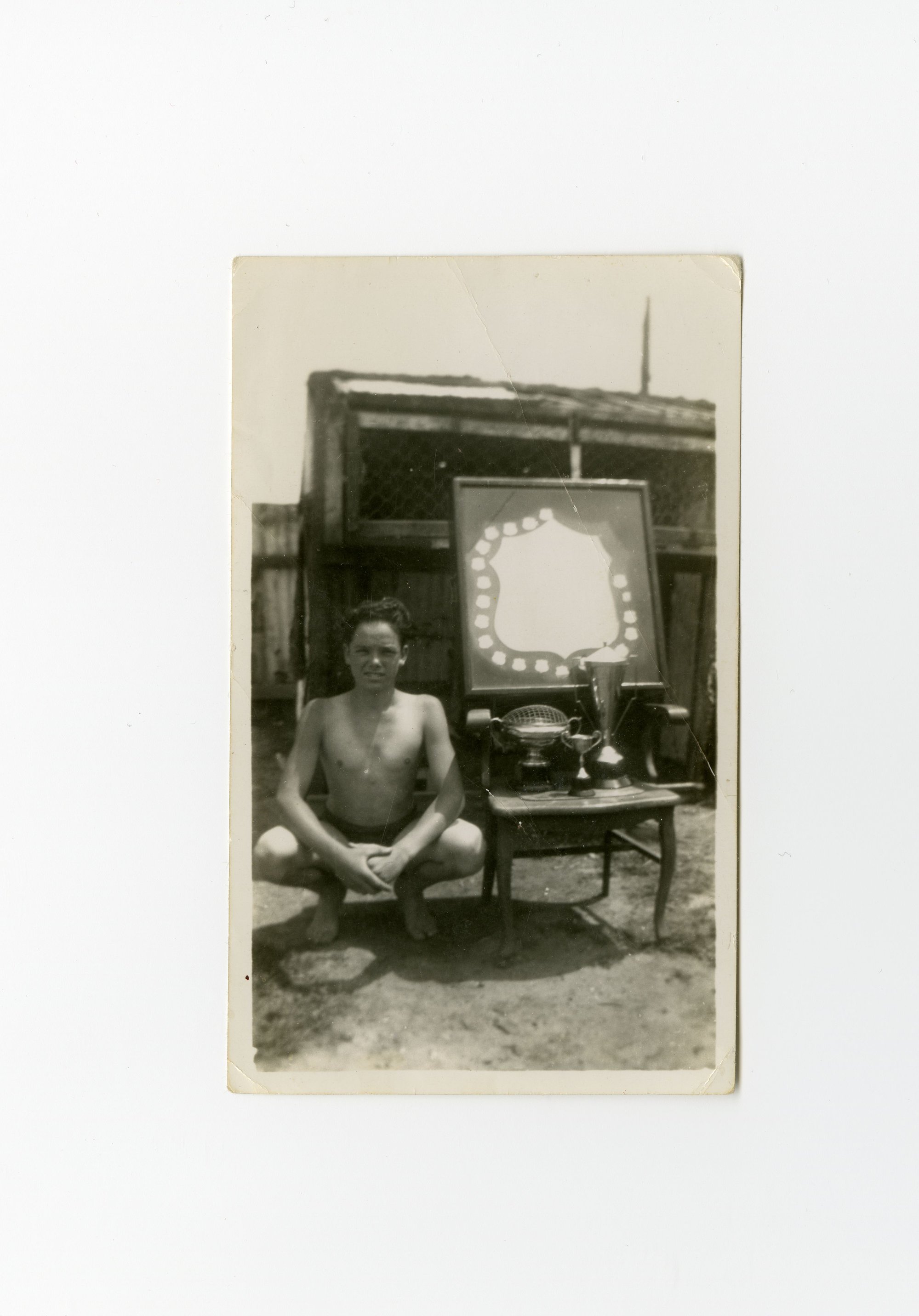 Photograph of swimmer with trophies