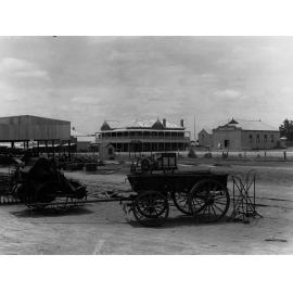 Carting wheat at Pinnaroo, showing carts and machinery, O'Hara's Pinnaroo Hotel and Pinnaroo institute in the background