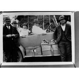 Photograph of men near automobile