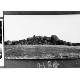 Rocky outcrop, Central Australia - motor vehicles in front of rocks - location unknown