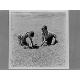 Two boys playing in the sand