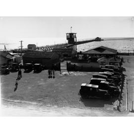 Semaphore showing the street before the beach and automobiles in parking area