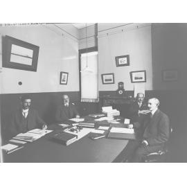Staff Members of the Harbours Board - sitting at a table in an office