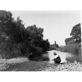 River Torrens view near Paradise with man kneeling on river bank