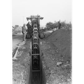 Glenelg Sewers showing machine digging a ditch