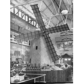 Exhibition for the Department of Agriculture showing windmill, grains surrounding windmill