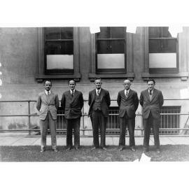 Five men standing in a row - unidentified