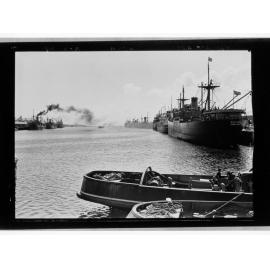 Ships and tugs lined up alongside dock