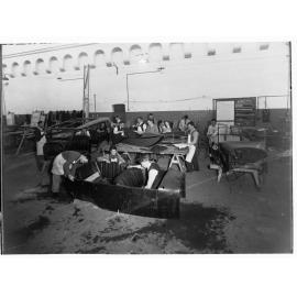 Students working on automobiles at trades school