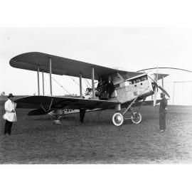 A de Havilland aeroplane, a DH50A, named Bellbird (probably located at an aerodrome in Parafield) - two men getting into plane