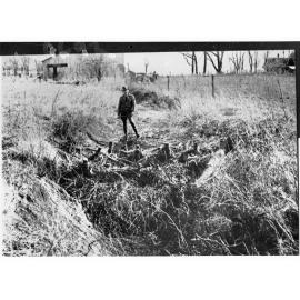 Man Standing by a Small Home-Made Dam