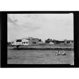 Port Pirie - three children sitting on grass looking over at some buildings