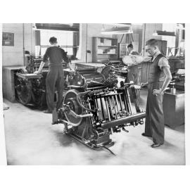 Printers Trade School Showing Two Young Men Working Printing Machine