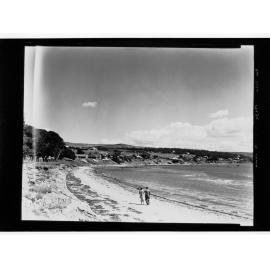 Two people walking on beach