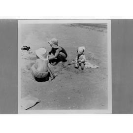 Three children playing in the sand