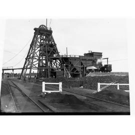 Moonta Mines view of Taylor Head Gear and Ore Sorting Plant - Men standing in front of plant with a bicycle