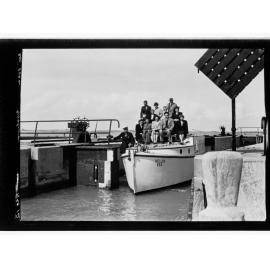 Goolwa - people sitting on top of small boat next to pier