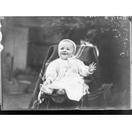 Baby in pusher sitting in garden