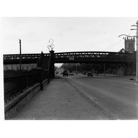 Morphett Street bridge overway looking east showing automobiles on North Terrace, Holy Trinity Church of England in the background.