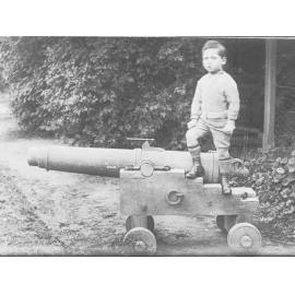 View of a little boy standing on a canon 