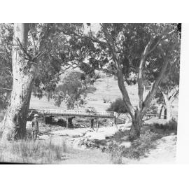 Rural View with Bridge Crossing River, Man in Foreground, Automobile on Bridge
