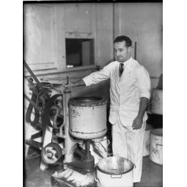 Egg pulping at Farmer's Union, man standing by a machine