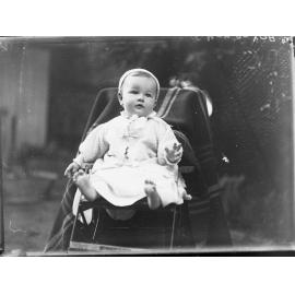 Baby in pusher sitting in garden