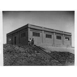 Glenelg Sewers showing men at top of a staircase near a building
