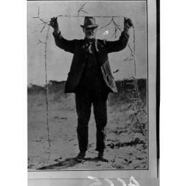 Man Holding Up Tree Roots