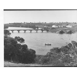 Two Men in Rowboat on Glenelg River with Housing in Background