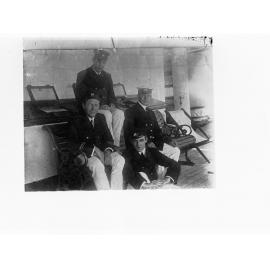 Four Navy men sitting on a bench