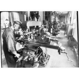 Student standing by a machine at Trades School