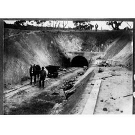 Construction of water culvert through hills - man and horse in foreground